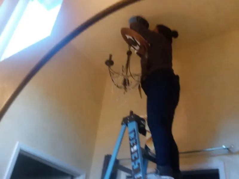 Electrician installing a chandelier in a Upper Merion residence
